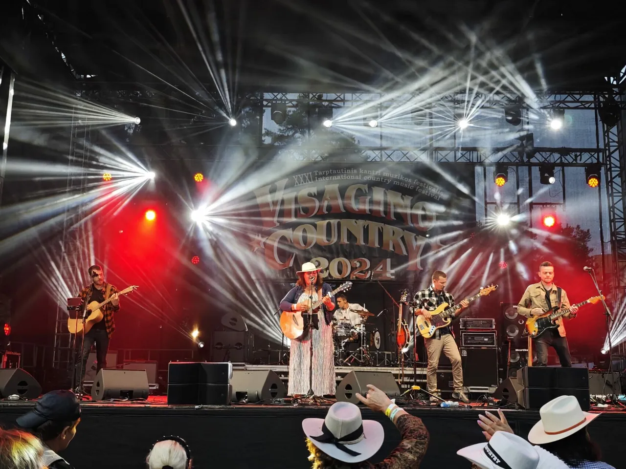 Country band performing under stage lights at Visagino Country in 2024